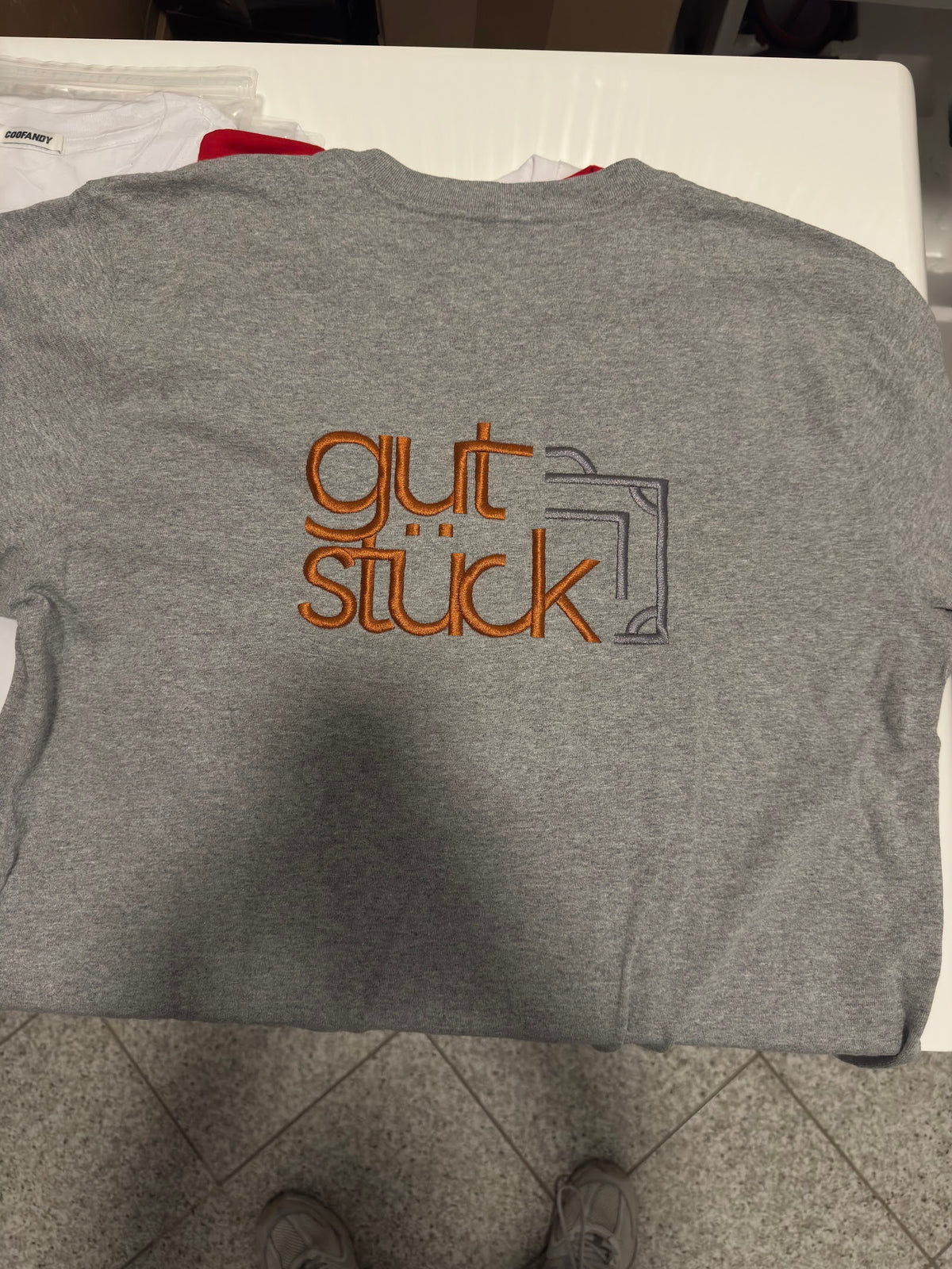 Graues Shirt mit mehrfarbig gesticktem Logo